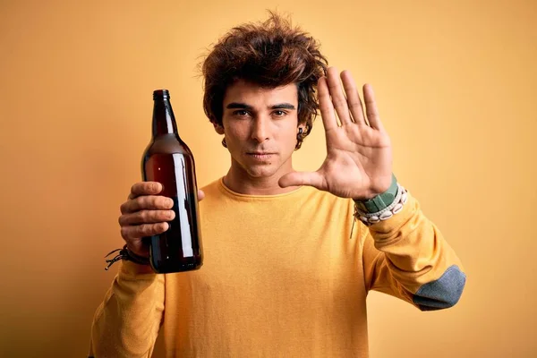 Ung Stilig Man Dricka Flaska Stående Över Isolerad Gul Bakgrund — Stockfoto