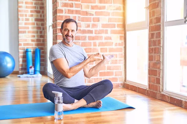 Schöner Sportler Mittleren Alters Sitzt Auf Matte Und Macht Stretching — Stockfoto