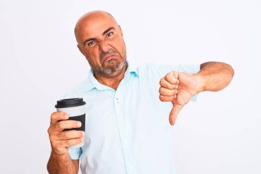 Middle age man drinking take away coffee standing over isolated white background with angry face, negative sign showing dislike with thumbs down, rejection concept