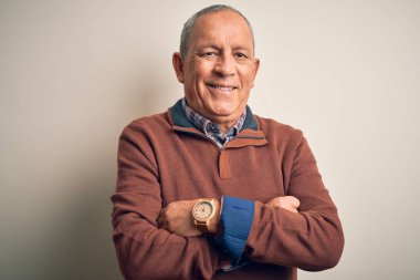 Soyutlanmış beyaz arka plan üzerinde duran zarif süveter giyen yakışıklı adam kollarını kavuşturup kameraya bakarken gülümsüyor. Pozitif kişi.