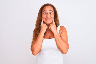 Middle age mature woman standing over white isolated background Smiling with open mouth, fingers pointing and forcing cheerful smile