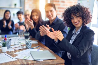 Bir grup iş adamı mutlu ve kendinden emin gülümsüyor. Birlikte çalışırken yüzümüzde gülümsemeyle kameraya bakıp ofisi alkışlıyorduk.