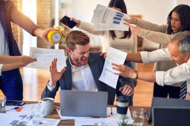 Group of business workers working together. Partners stressing one of them at the office