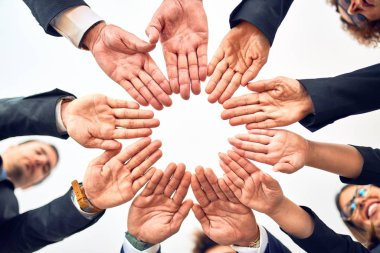 Bir grup iş adamı mutlu ve kendinden emin gülümsüyor. Yüzünde bir gülümsemeyle bir çemberin üzerinde durarak ofiste el ele tutuşarak semboller çizerek..