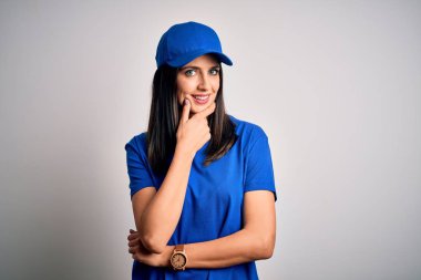 Mavi arka planda duran mavi gözlü genç teslimatçı kadın kameraya kendinden emin bir şekilde bakıyor kollarını kavuşturmuş ve çenesini kaldırmış gülümsüyor. Olumlu düşünüyorum..