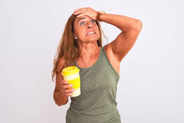 Orta yaşlı olgun bir kadın izole edilmiş arka planda bir fincan kahve içerken el ele, utanç ve şaşkınlık dolu, sinirli ve hayal kırıklığına uğramış bir halde. Hata için korku ve üzüntü.