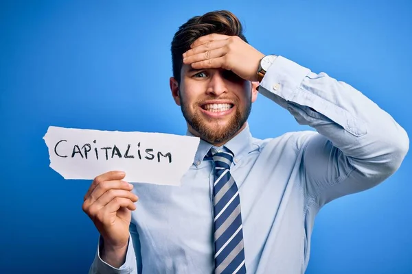 Młody Blond Biznesmen Brodą Niebieskimi Oczami Trzymający Papier Przesłaniem Kapitalizmu — Zdjęcie stockowe