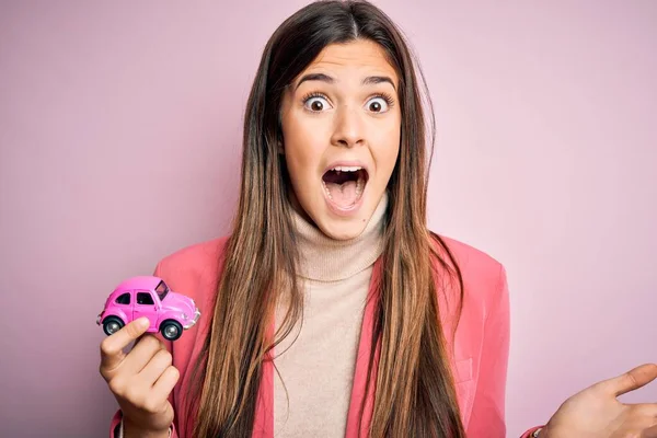 Jovem Menina Bonita Segurando Brinquedo Carro Pequeno Sobre Fundo Rosa — Fotografia de Stock