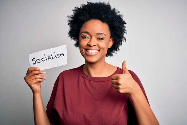 Young African American afro politician woman with curly hair socialist party member happy with big smile doing ok sign, thumb up with fingers, excellent sign