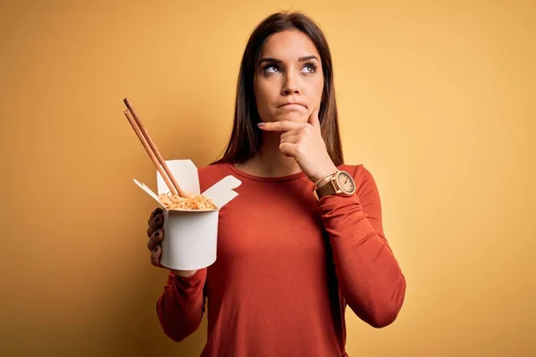 Young Beautiful Brunette Woman Eating Takeaway Noodles Using Chopsticks Serious — Stock Photo, Image