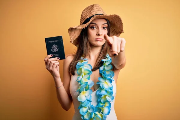 水着を着て休暇中の若い美しい観光客の女性とハワイのレイは カメラに指で指してパスポートを保持し あなたに 手のサイン 正とフロントから自信を持ってジェスチャー — ストック写真