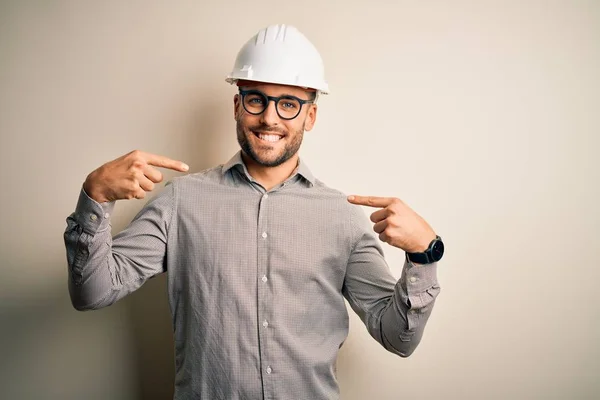年轻的建筑师 头戴建筑工地安全帽 背景偏僻 面带微笑 带着自信 用手指指着自己 自豪而快乐 — 图库照片