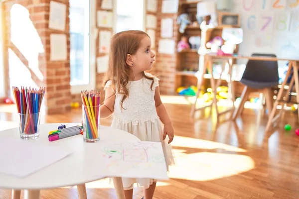 愛らしいブロンド幼児遊び回る多くのおもちゃで幼稚園 — ストック写真