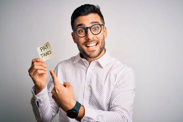 Joven Hombre Guapo Sosteniendo Papel Recordatorio Con Pagar Impuestos Mensaje — Foto de Stock