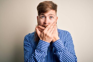 Arkaplanda sakallı, kızıl saçlı yakışıklı bir iş adamı ağzını yanlışlıkla ellerle kapatmış. Gizli konsept.