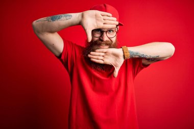 Gözlüklü yakışıklı teslimatçı ve izole edilmiş arka planda kırmızı şapkalı neşeli gülümseyen, elleri havada bir böceği dikizleyen. Şaşırdım ve çıktım.