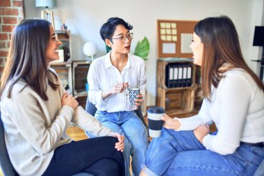 Güzel iş kadınları mutlu gülümsüyor. Gülümseyerek oturup konuşmak ofiste dinlenmek.