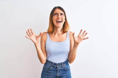 Güzel kızıl saçlı kadın arka planda duruyor çılgın ve kızgın bir şekilde bağırıyor ve agresif bir ifade ve kolla bağırıyor. Hayal kırıklığı konsepti.