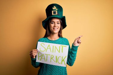 Yeşil şapkalı kadın Aziz Patrick Günü 'nü kutluyor Aziz Patrick' in mesajıyla bayrağı tutuyor.