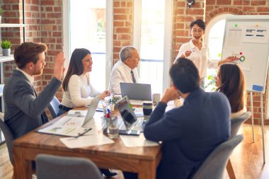 Group of business workers working together in a meeting. One of them making presentation to colleagues at the office