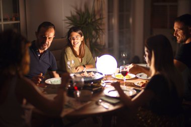 Güzel bir aile akşam yemeğinde terasta konuşuyor ve gülümsüyor