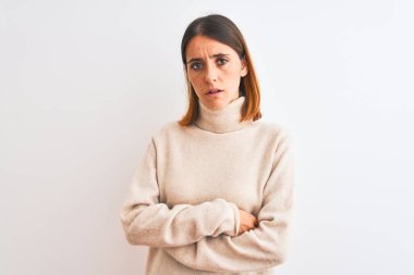 Güzel kızıl saçlı kadın, izole edilmiş arka plan kuşkucu ve gergin, kollarını kavuşturup yüzüne karşı onaylamadığı bir ifadeyle balıkçı yaka kazak giyiyor. Negatif kişi.