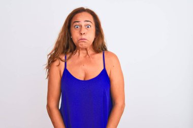 Orta yaşlı olgun bir kadın, beyaz, soyutlanmış arka planda durmuş komik yüzüyle yanaklarını şişiriyor. Havayla şişmiş ağız, çılgın bir ifade..