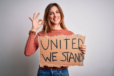 Beautiful brunette woman holding banner with united we stand lettering