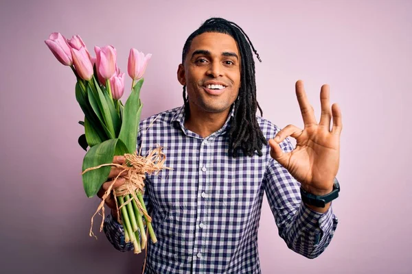 若いですアフリカ系アメリカ人アフロロマンチックな男とともにフリンクチューリップの花束を持っています指でOkサインをします 優れたシンボル — ストック写真