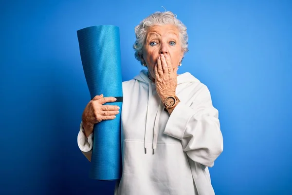 Senior Beautiful Sporty Woman Holding Mat Yoga Standing Isolated Blue — Stock Photo, Image