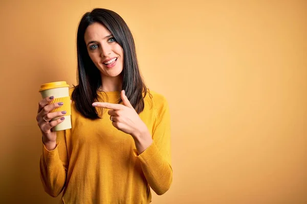 Młoda Kobieta Niebieskimi Oczami Trzyma Filiżankę Kawy Stojącej Żółtym Tle — Zdjęcie stockowe