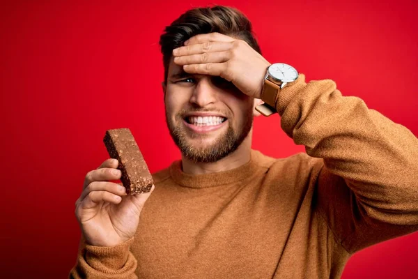 Jovem Loiro Com Barba Olhos Azuis Comendo Barra Proteína Chocolate — Fotografia de Stock