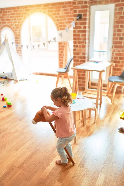 Schöne Blonde Kleinkind Mädchen Reiten Pferd Mit Stock Spielzeug Kindergarten — Stockfoto