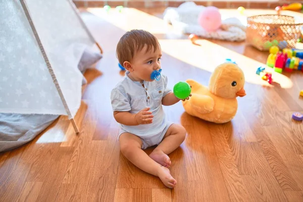 Adorable Toddler Sitting Floor Using Pacifier Lots Toys Kindergarten — Stock Photo, Image