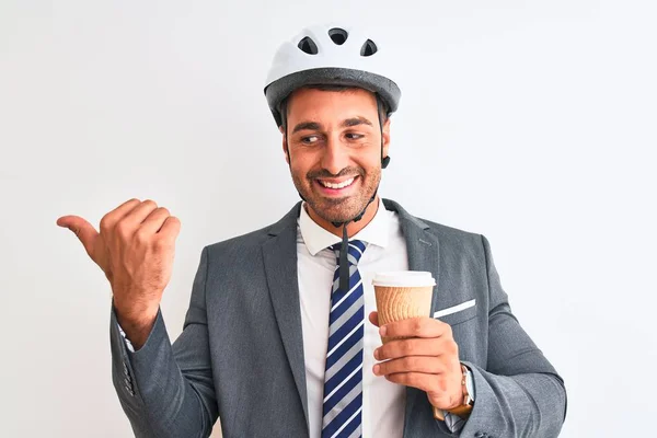 자전거 헬멧을 잘생긴 사업가가 배경을 가리키며 커피를 가져가며 얼굴로 웃으며 — 스톡 사진