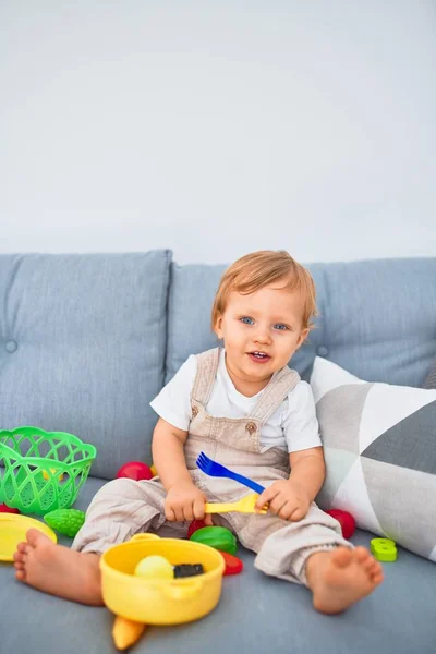 Sevimli Sarışın Çocuk Mutlu Bir Şekilde Kanepede Oturup Evde Plastik — Stok fotoğraf