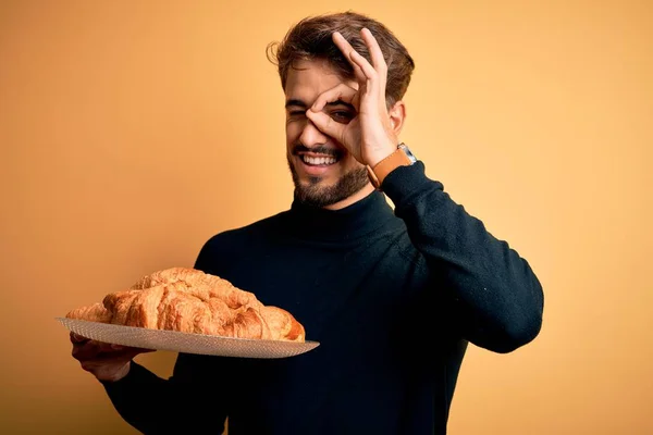 Young Man Beard Holding Plate Croissants Standing Isolated Yellow Background — Stock Photo, Image
