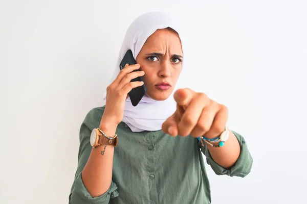 Молодая Арабская Женщина Хиджабе Говорит Смартфоне Изолированном Фоне Указывая Пальцем — стоковое фото