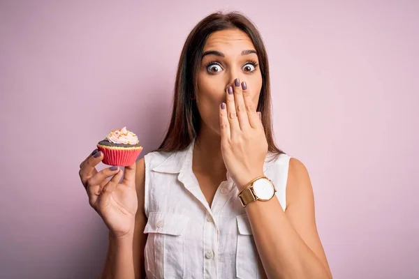 Jovem Bela Morena Comendo Cupcake Chocolate Sobre Fundo Rosa Isolado — Fotografia de Stock