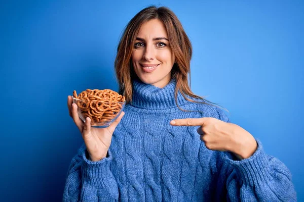 Young Beautiful Brunette Woman Holding Bowl German Baked Pretzels Blue — Stok fotoğraf