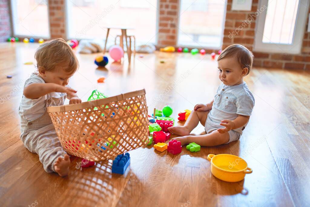 Beautiful toddlers playing around lots of toys at kindergarten