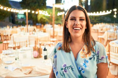 Parti şöleninde mutlu ve neşeli gülümseyen gelinlikli güzel ve zarif bir kadın.