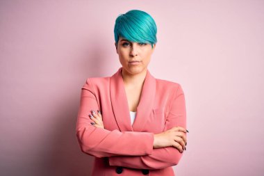 Mavi saçlı, pembe arka plan üzerinde ceketi olan, kuşkucu ve gergin genç ve güzel bir iş kadını. Yüzünde çapraz kollarla onaylamayan bir ifade var. Negatif kişi.