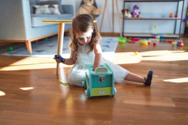 Anaokulunda oyuncak oyuncaklarıyla oynayan sevimli sarışın çocuk.