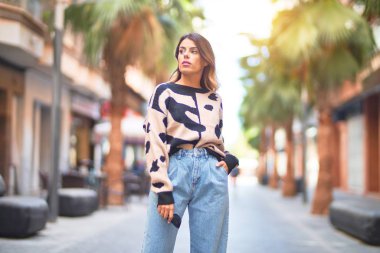 Mutlu ve kendinden emin gülümseyen genç ve güzel bir kadın. Şehir caddesinde ayakta ve yürüyorum.