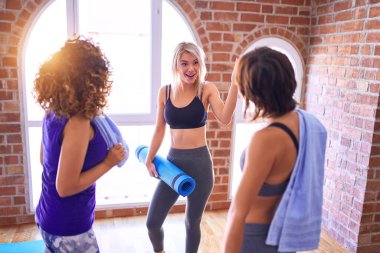 Mutlu gülümseyen genç ve güzel bir sporcu grubu. Beden dersinde yoga dersinden önce ayakta konuşma.