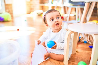 Anaokulunda renkli oyuncaklar arasında mutlu güzel bir bebek.