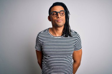 Genç, yakışıklı, Afro-Amerikan bir adam. Rasta desenli tişört ve gözlük takıyor. Gülümsüyor ve yan tarafa bakıyor..