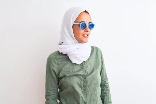 若いアラブ人女性の顔に笑顔で横に離れて見て孤立した背景の上にヒジャーブと夏のサングラスを着用し 自然な表現 自信を持って — ストック写真