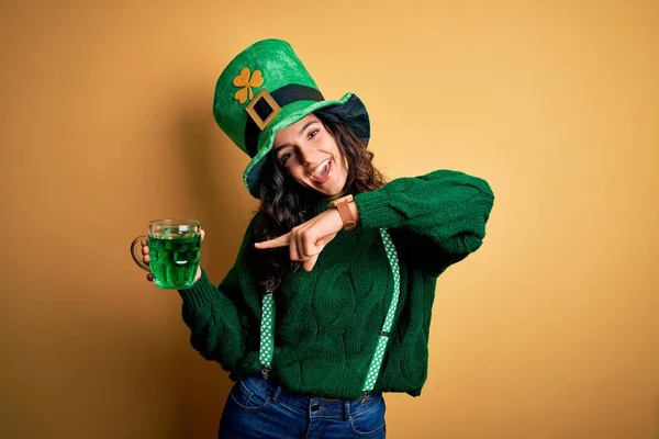 美しい巻き毛の女性を身に着けている帽子を飲んで瓶の緑の飲み物で聖人のパトリックの日非常に幸せなポインティングで手と指 — ストック写真